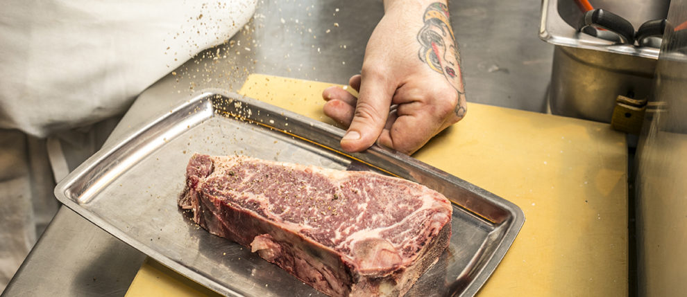 Steak being seasoned