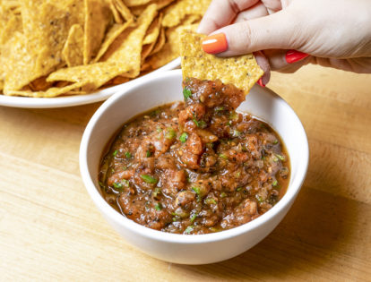 chip dipping into savory charred salsa